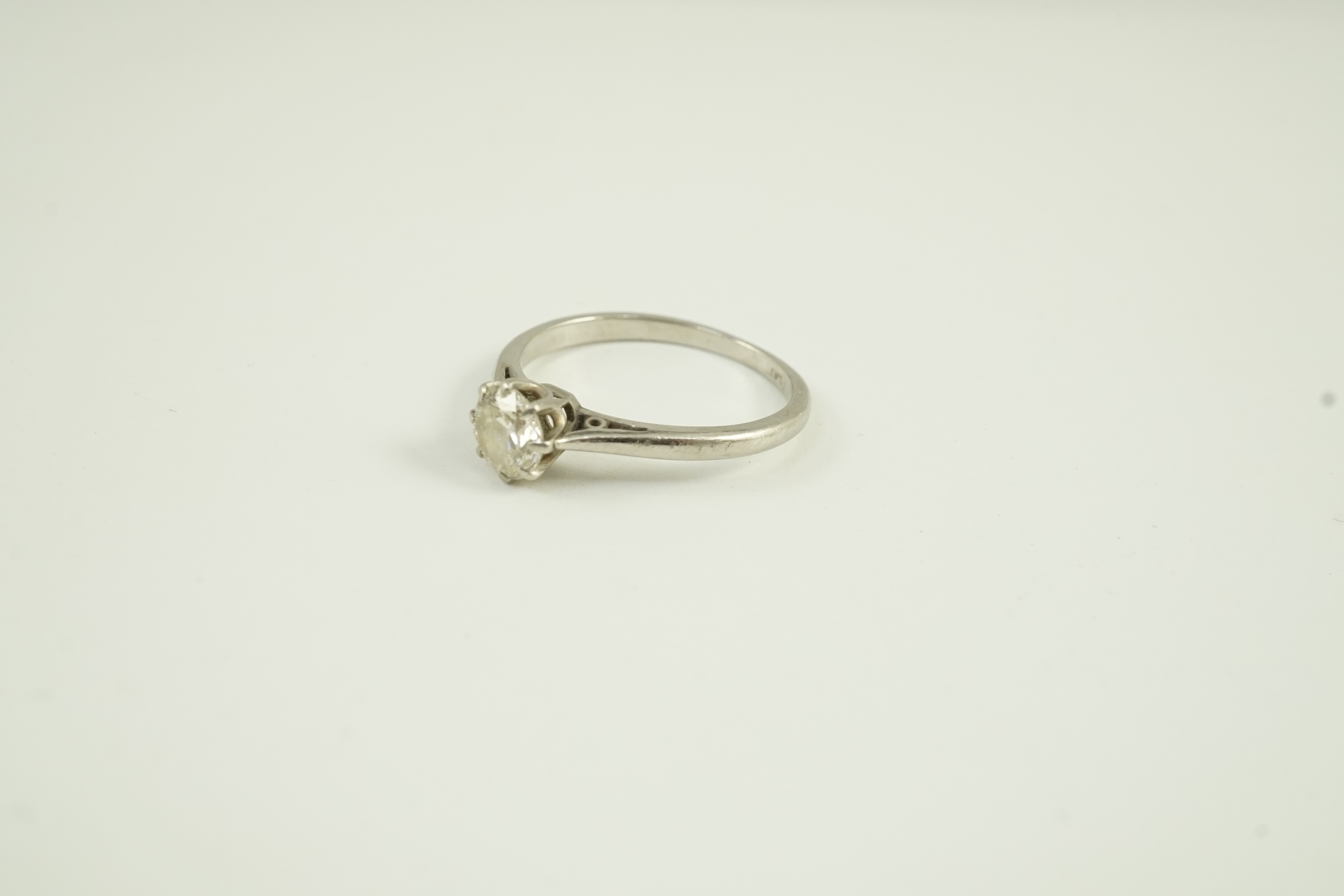 A white metal (stamped plat) and solitaire diamond set ring, size K, gross weight 2.6 grams
